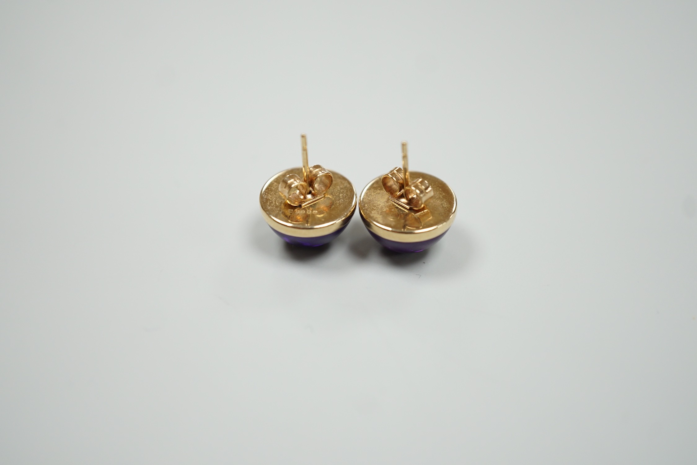 A modern pair of 9ct gold and cabochon amethyst set ear studs, diameter 14mm, gross weight 4 grams.